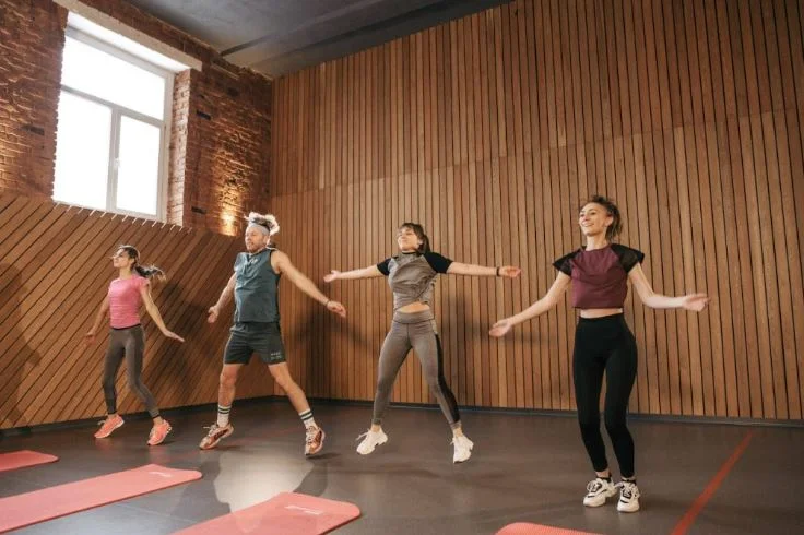 A group of people performing an energetic Zumba dance exercise routine in a fitness studio.zumba workout