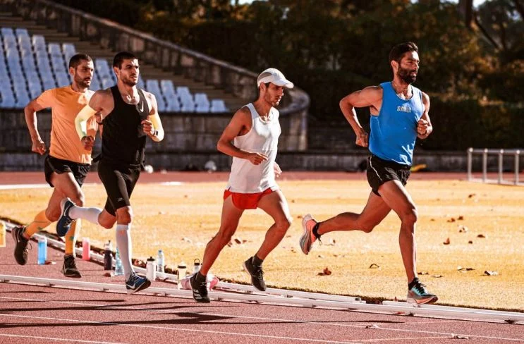 A person running on an outdoor path, demonstrating leg muscle engagement during a workout