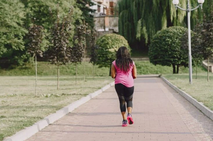 Woman jogging on a park pathway.Brisk Walking Benefits for Health and Weight Loss