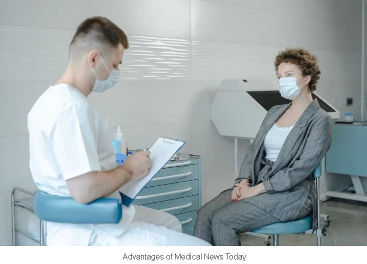 Medical News Today Review,''A male healthcare worker and a female healthcare worker wearing light blue surgical face masks inside a bright, modern medical facility.